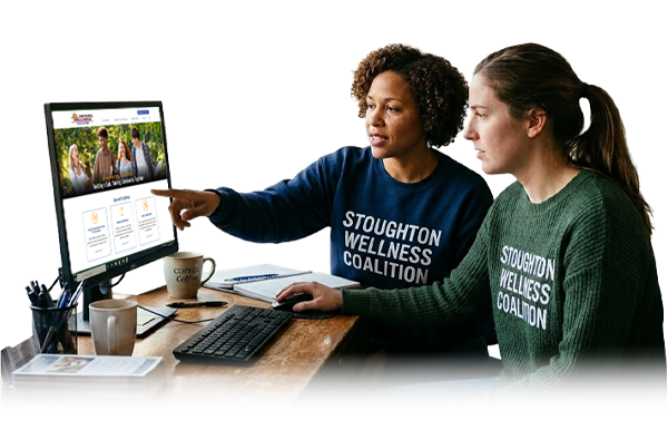 Two women looking at Stoughton Wellness Coalition on computer monitor.